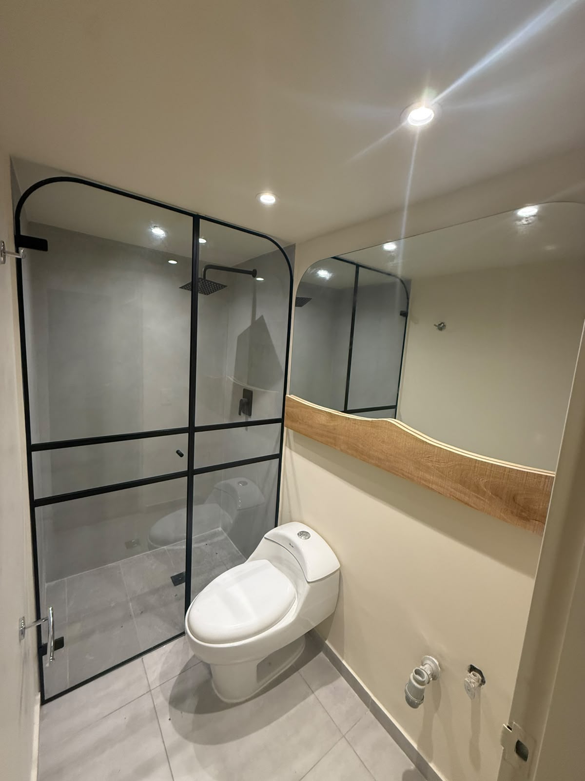 Baño con cabina en vidrio y espejo a medida
