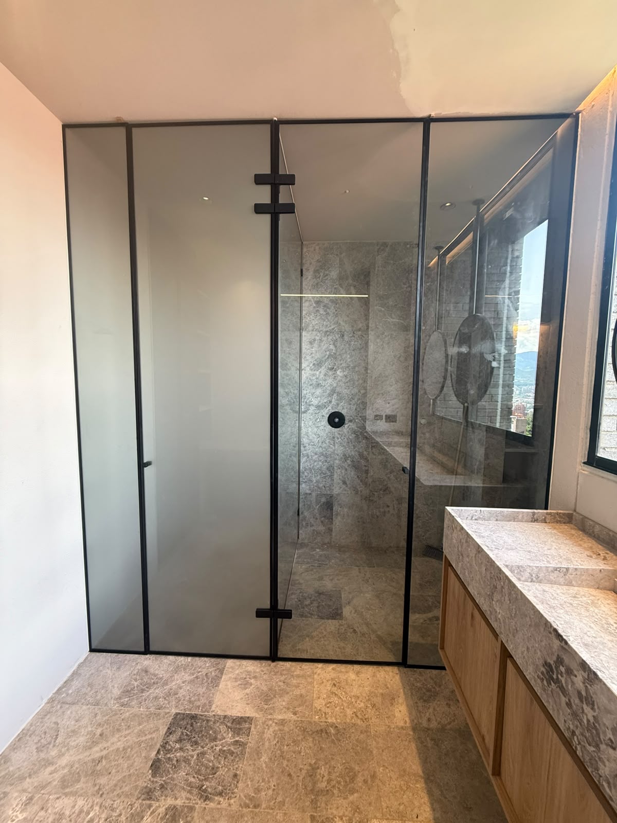 Cabina de baño en vidrio esmerilado con perfiles negros