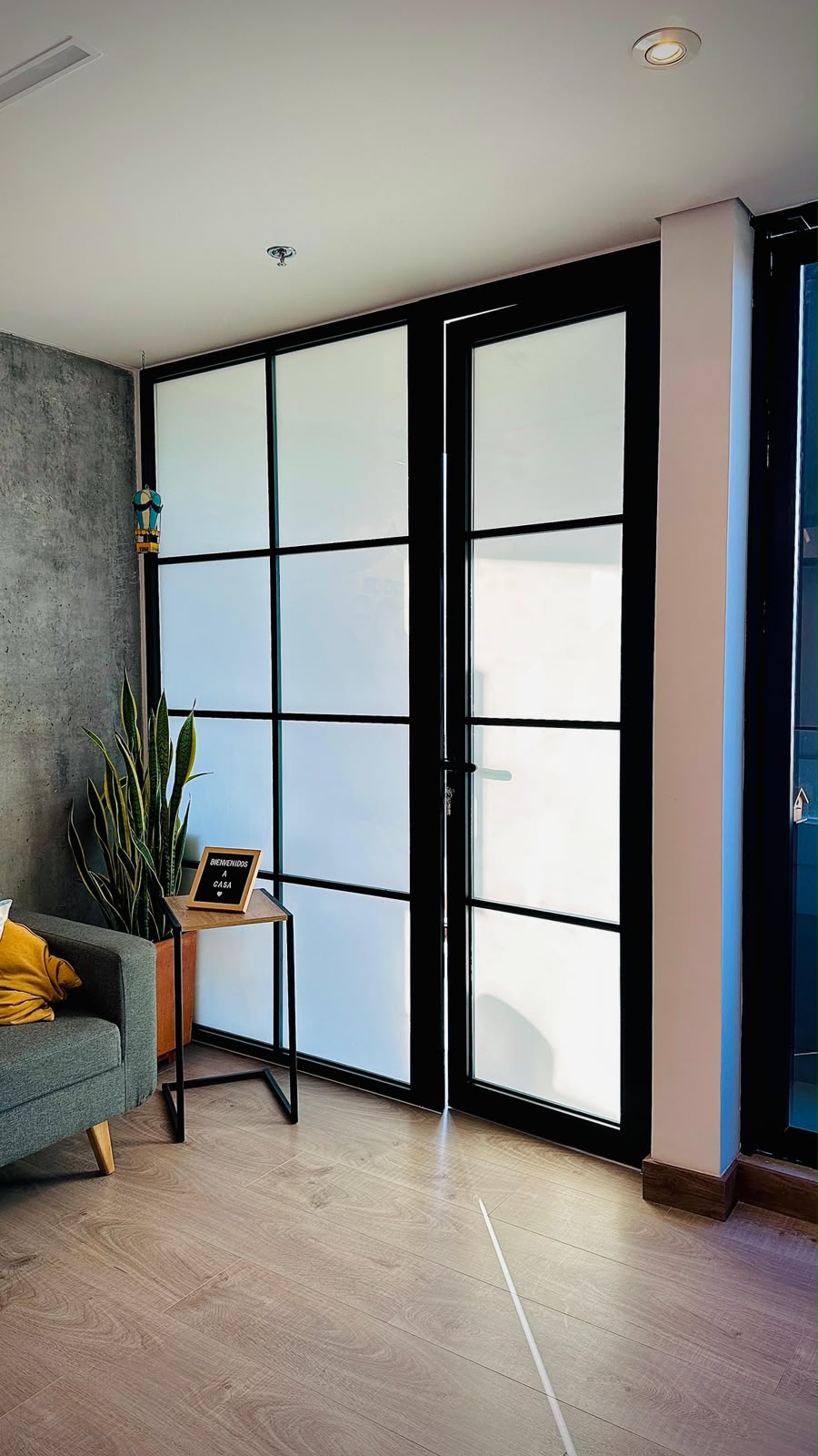Ventana en esquina con perfiles negros vista desde el jardín